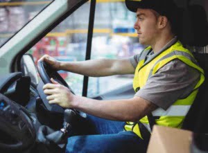 driver in high vis sits behind the sterring wheel 